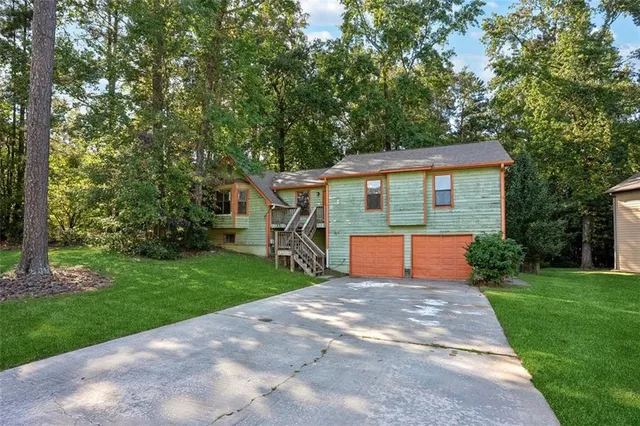 a front view of a house with yard and green space