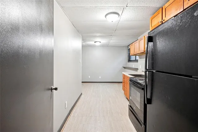 a view of a kitchen with a sink and refrigerator