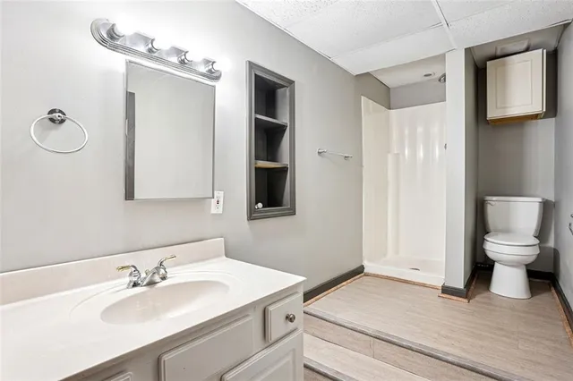 a bathroom with a sink a toilet and shower