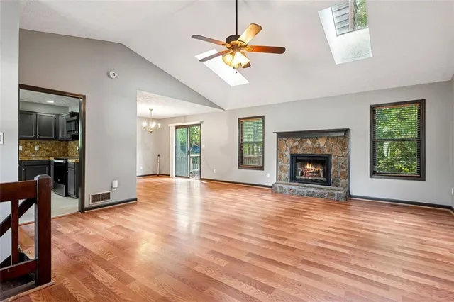 a view of an empty room with window and wooden floor
