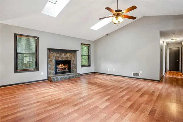 an empty room with windows and a fireplace