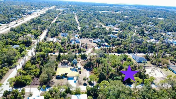 an aerial view of residential houses with outdoor space and trees