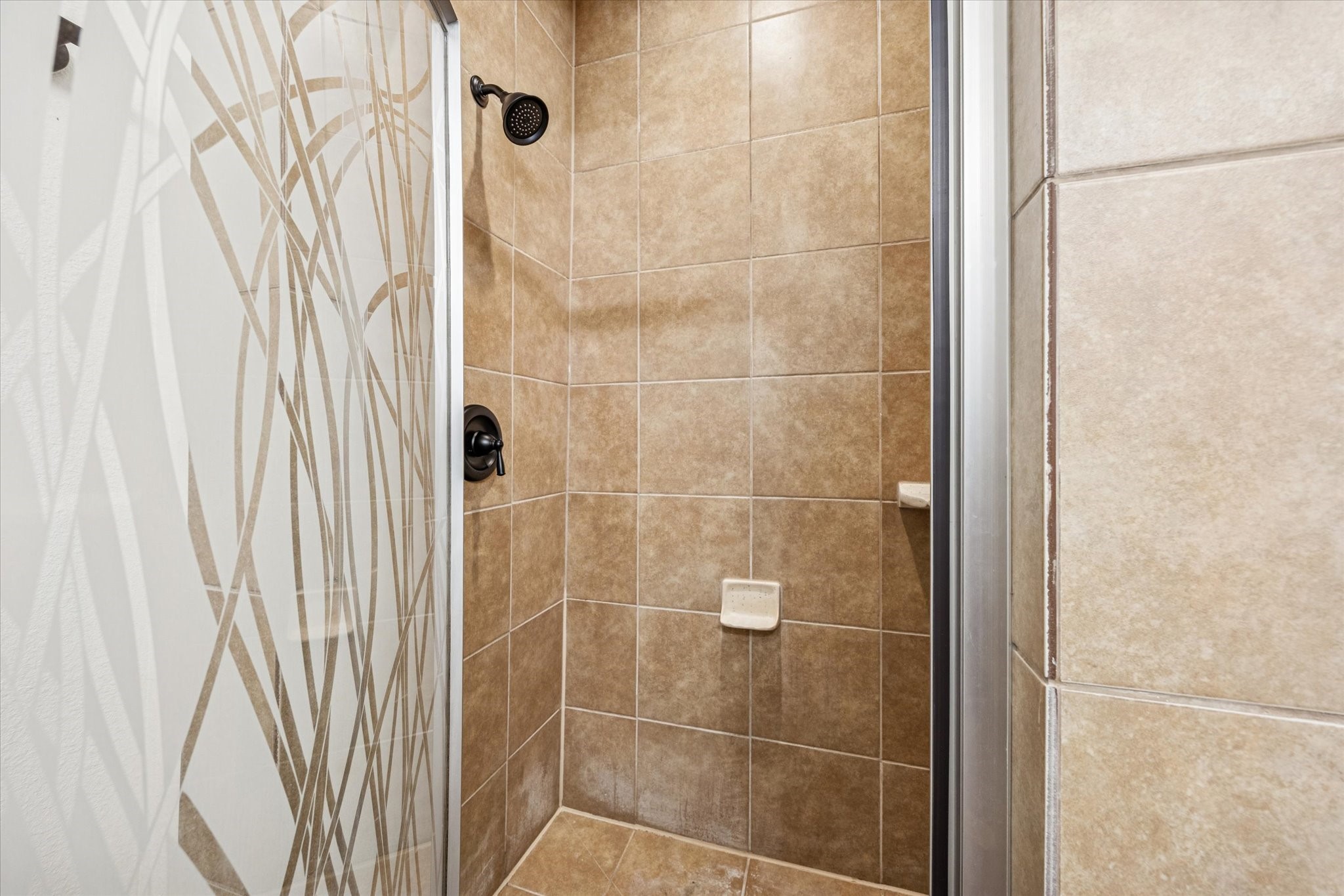5402 Jonathan Lane Houston, TX 77011 - Photo 19 of 33 Experience luxury in the primary bathroom with a stylish walk-in shower, featuring elegant tile work and modern fixtures.