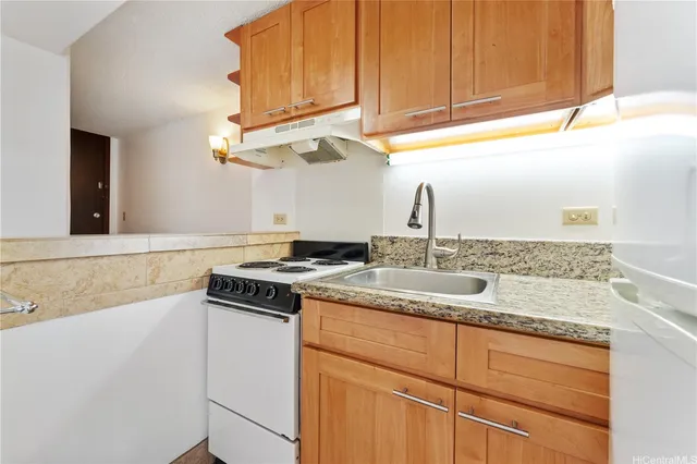 a kitchen with stainless steel appliances granite countertop a sink and a stove
