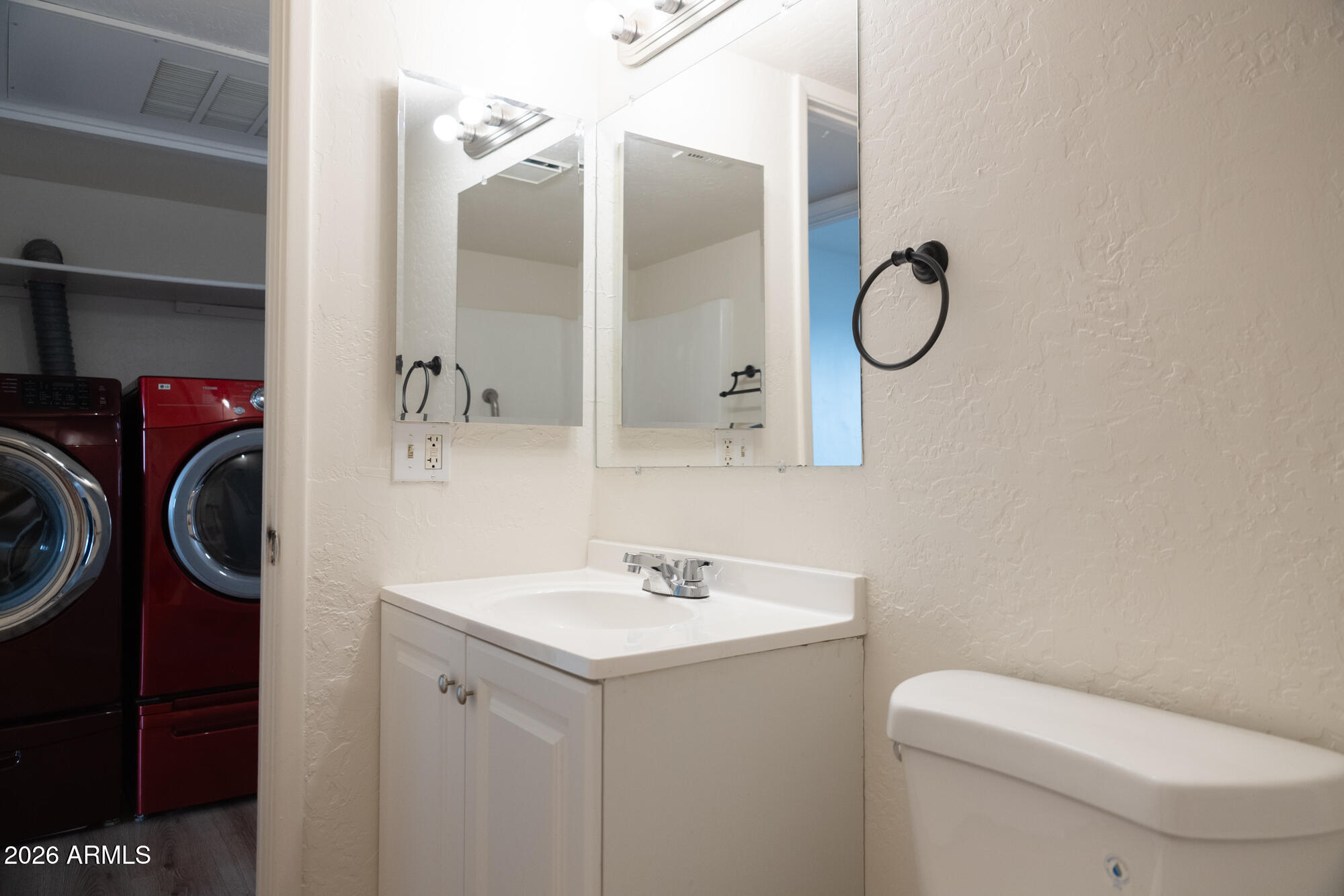 12123 West Bell Road, Unit 219 Surprise, AZ 85378 - Photo 11 of 23 a bathroom with a sink a toilet and a mirror