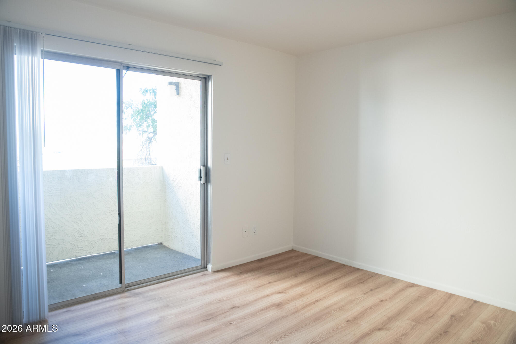12123 West Bell Road, Unit 219 Surprise, AZ 85378 - Photo 14 of 23 a view of an empty room with wooden floor and a window