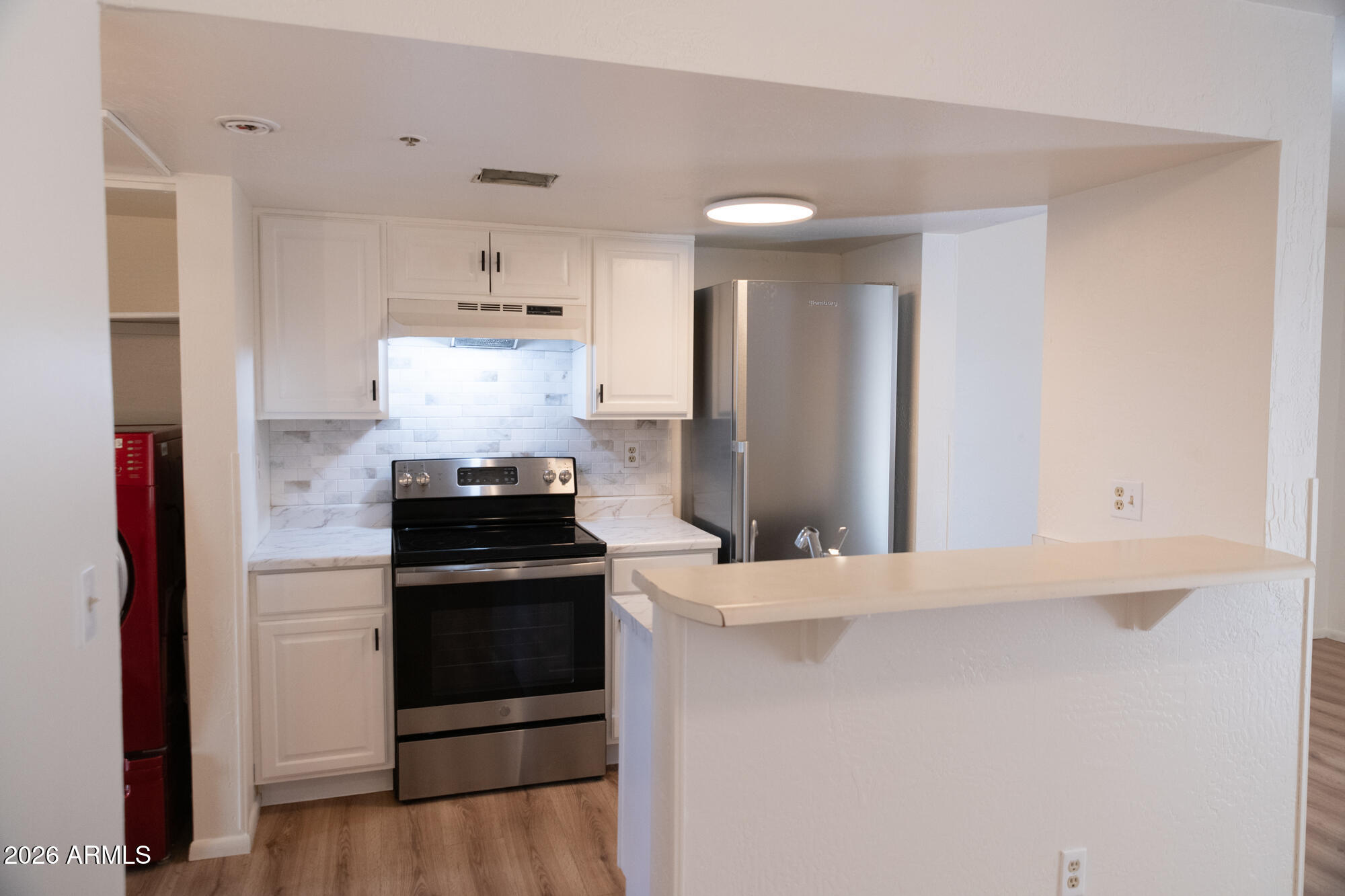 12123 West Bell Road, Unit 219 Surprise, AZ 85378 - Photo 2 of 23 a kitchen with a stove and a refrigerator