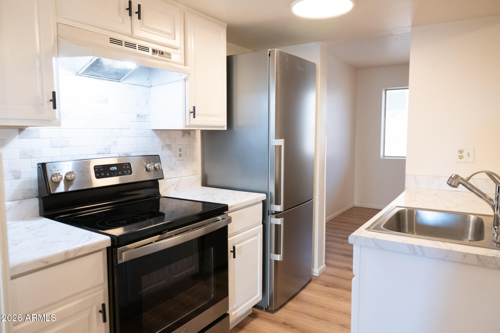 12123 West Bell Road, Unit 219 Surprise, AZ 85378 - Photo 3 of 23 a kitchen with cabinets and steel stainless steel appliances