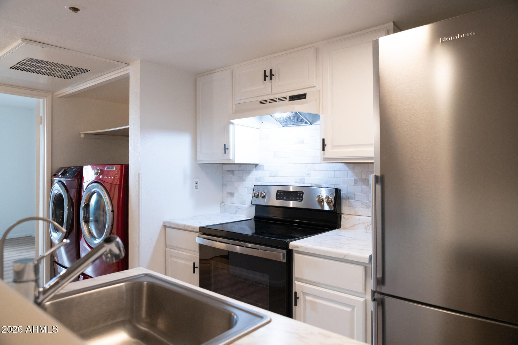 12123 West Bell Road, Unit 219 Surprise, AZ 85378 - Photo 4 of 23 a kitchen with a stove and a refrigerator