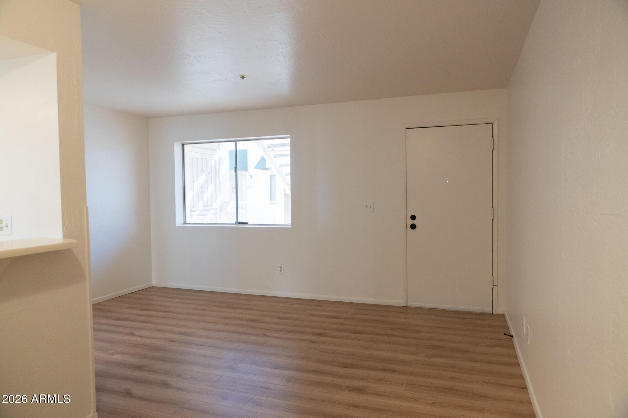12123 West Bell Road, Unit 219 Surprise, AZ 85378 - Photo 7 of 23 wooden floor in an empty room with a window