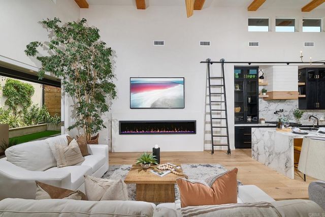a living room with furniture kitchen view and a large window