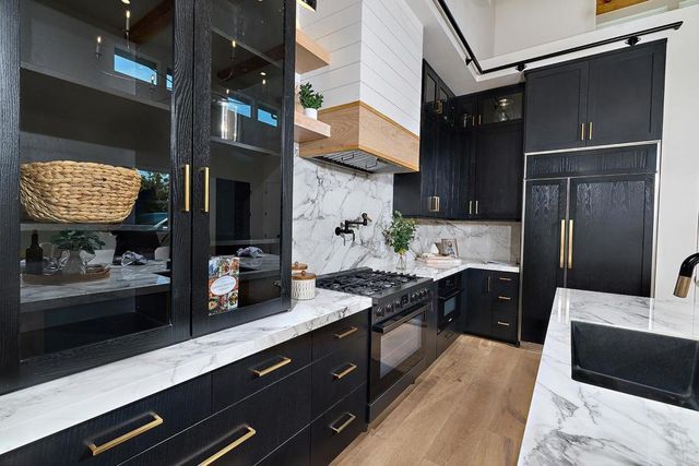a kitchen with stainless steel appliances granite countertop a refrigerator and a sink