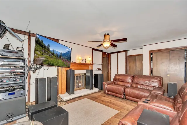 a living room with furniture a ceiling fan and a large window