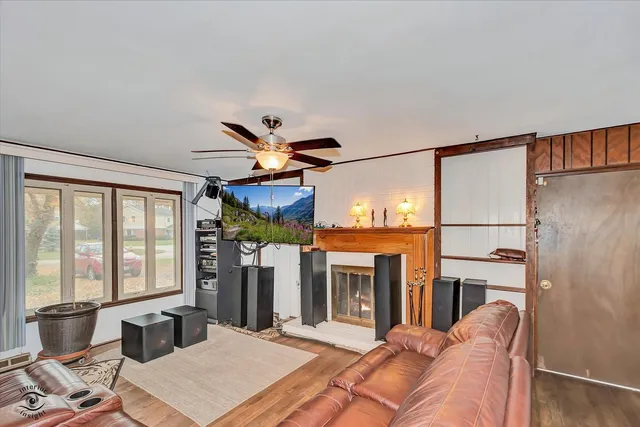 a living room with furniture a fireplace and a floor to ceiling window