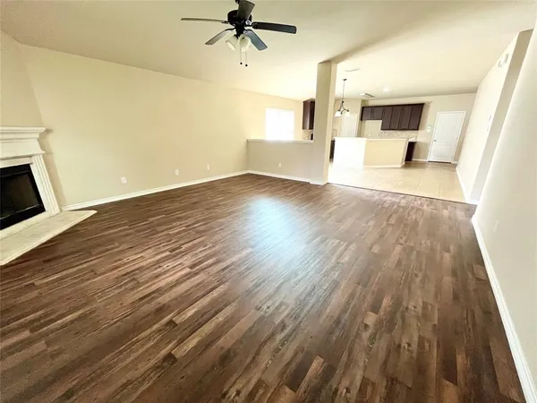 a view of a big room with wooden floor and windows