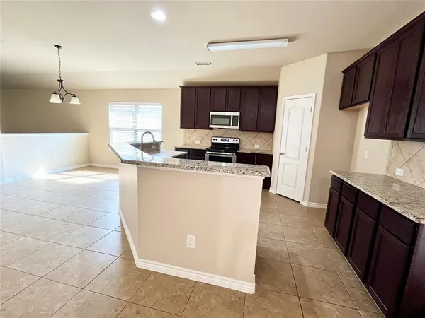 a kitchen with stainless steel appliances granite countertop a sink a stove a refrigerator and cabinets