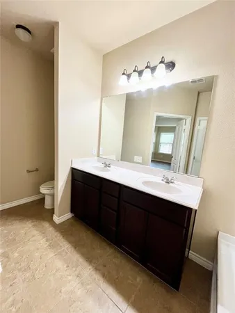a bathroom with a double vanity sink mirror and toilet