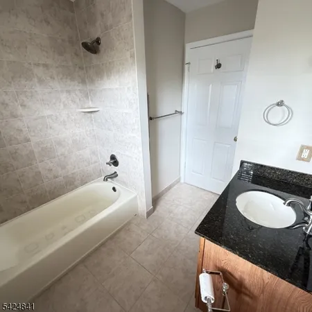 a bathroom with a granite countertop sink a toilet and bathtub