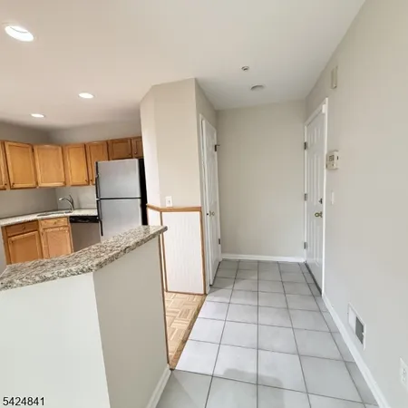 a kitchen with a refrigerator a stove top oven and cabinets
