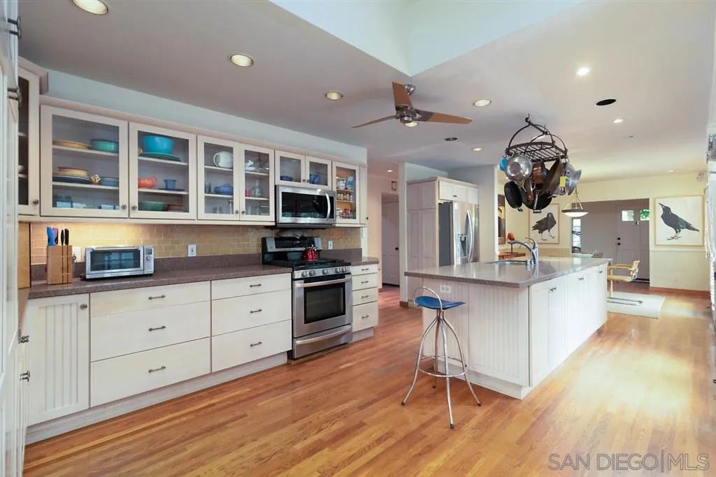 5004 Marlborough Drive San Diego, CA 92116 - Photo 12 of 25 a kitchen with granite countertop a stove and cabinets