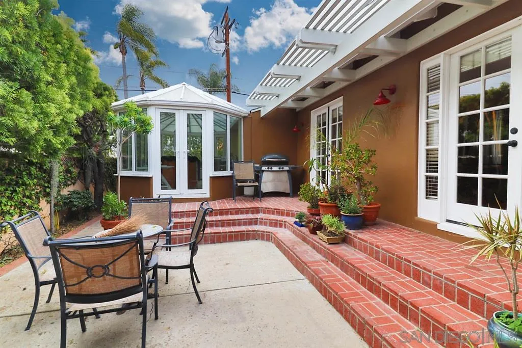 5004 Marlborough Drive San Diego, CA 92116 - Photo 16 of 25 a view of patio with a table and chairs under an umbrella with wooden floor