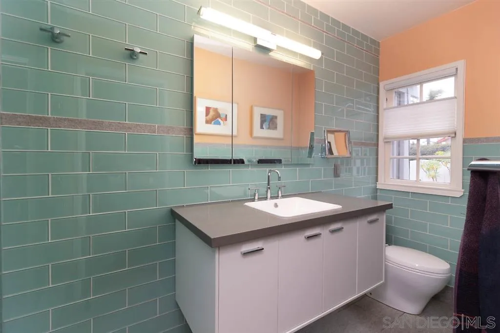 5004 Marlborough Drive San Diego, CA 92116 - Photo 19 of 25 a bathroom with a sink a toilet a mirror and a window
