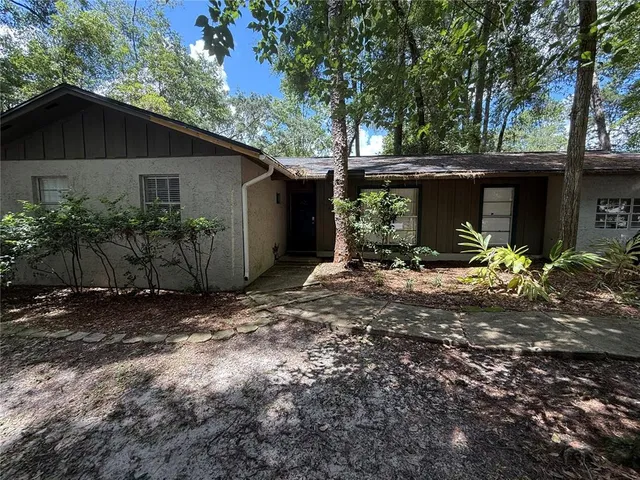a view of a house with yard and a large tree