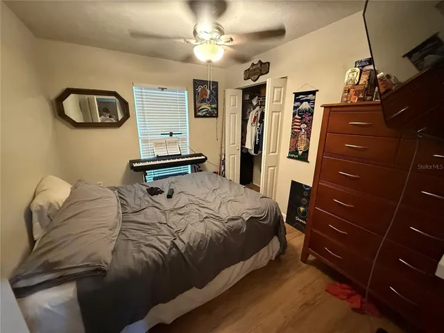 a bedroom with a bed a dresser and a chandelier