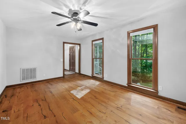 a view of an empty room and window with wooden floor