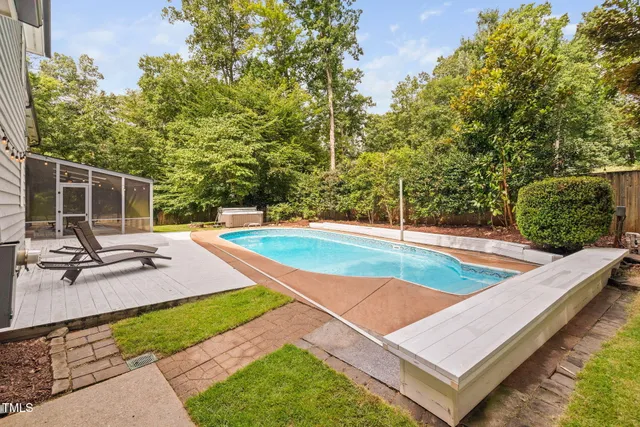 a view of a house with pool and a yard