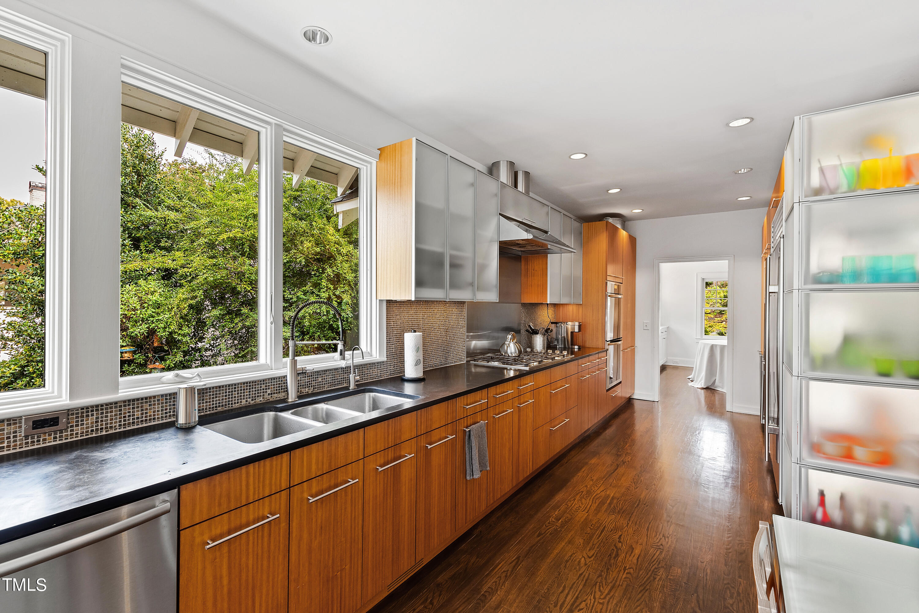 2212 The Circle Raleigh, NC 27608 - Photo 29 of 88 a large kitchen with stainless steel appliances wooden floor and a large window