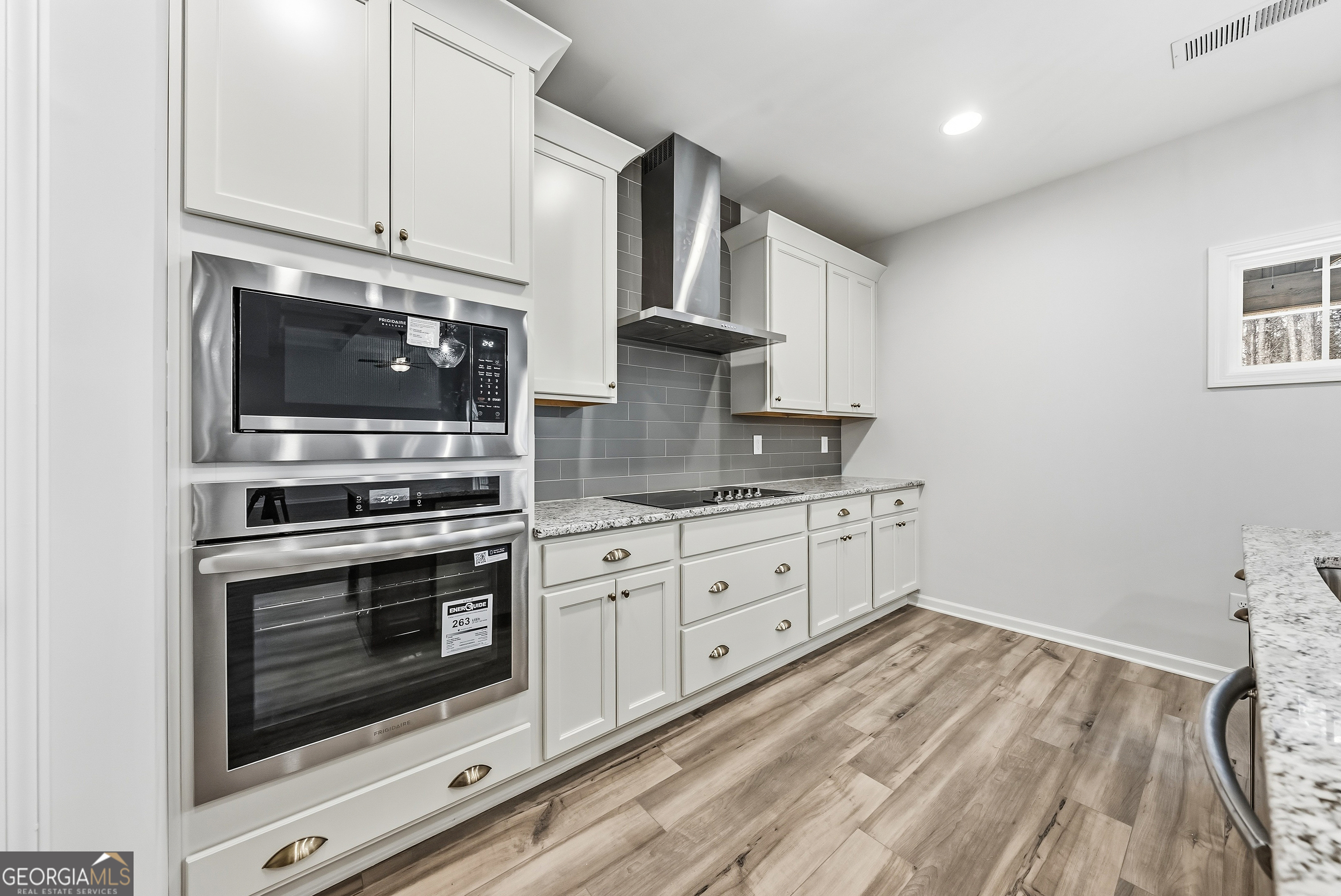 75 Oak Ridge Drive, Unit 4 Pine Mountain, GA 31822 - Photo 14 of 41 a kitchen with granite countertop white cabinets stainless steel appliances and wooden floor