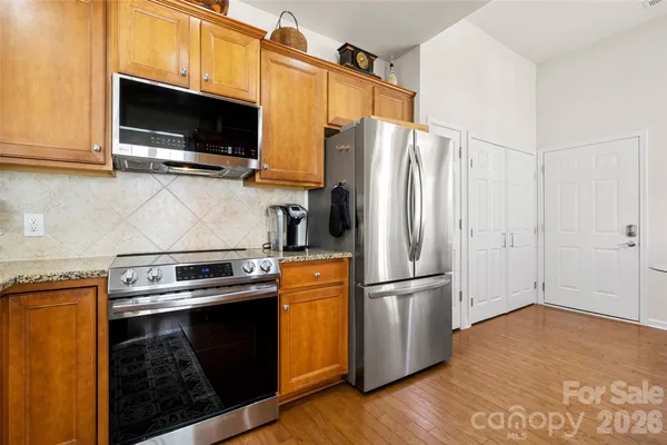 a kitchen with stainless steel appliances granite countertop a sink stove and microwave