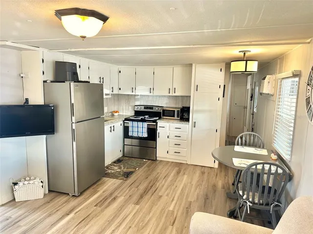 a kitchen with stainless steel appliances a refrigerator and a stove top oven