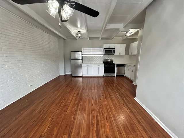 a view of a room with wooden floor and cabinets