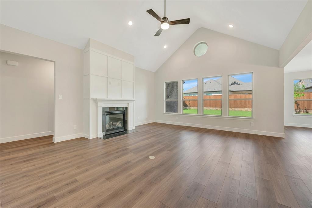 11460 Wulstone Road Fort Worth, TX 76052 - Photo 4 of 40 an empty room with wooden floor fireplace and windows