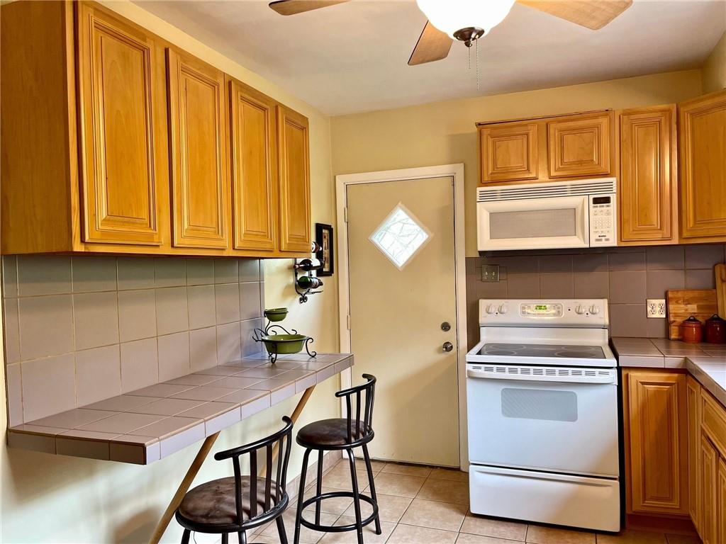 700 Ottillia Street Pittsburgh, PA 15210 - Photo 7 of 20 a kitchen with stainless steel appliances granite countertop a stove a microwave a sink and cabinets
