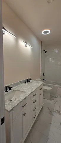 a bathroom with a granite countertop sink and a