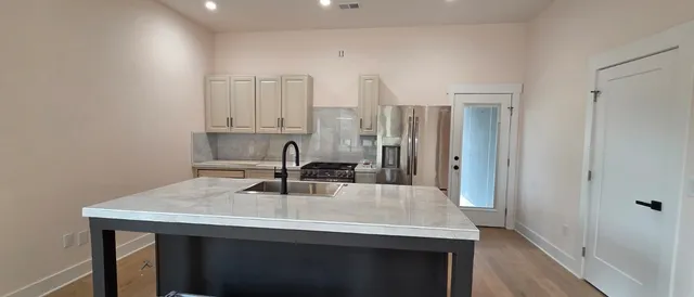 a kitchen with a sink a refrigerator and cabinets