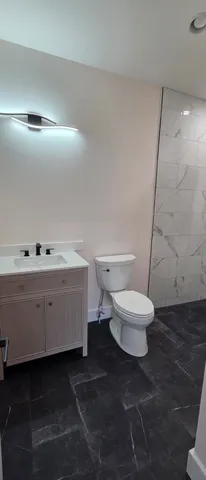 a bathroom with a toilet sink and a mirror