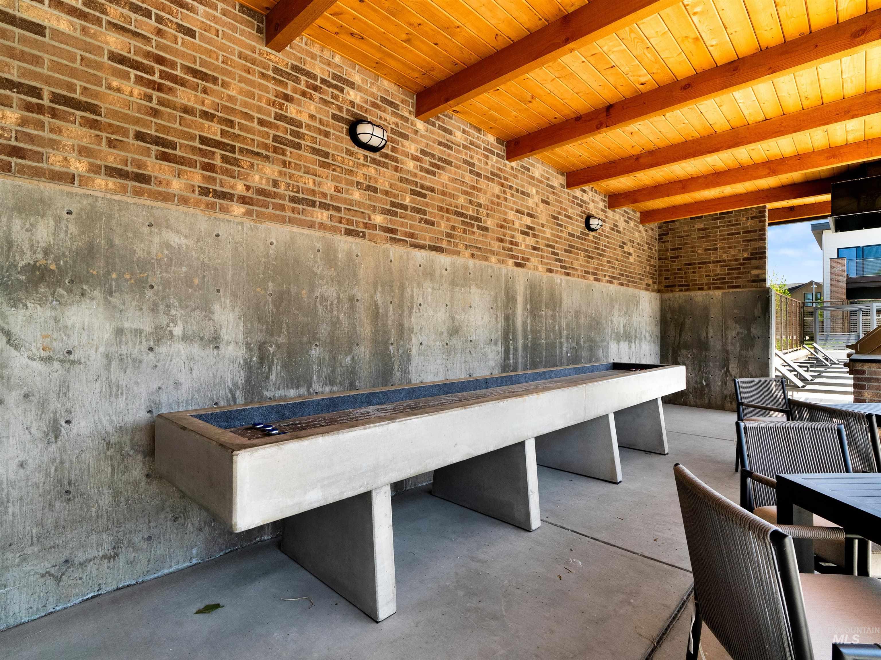 2526 West Rustic Forge Street Eagle, ID 83616 - Photo 13 of 50 Miscellaneous room with brick wall, concrete floors, and a wood ceiling with exposed beams