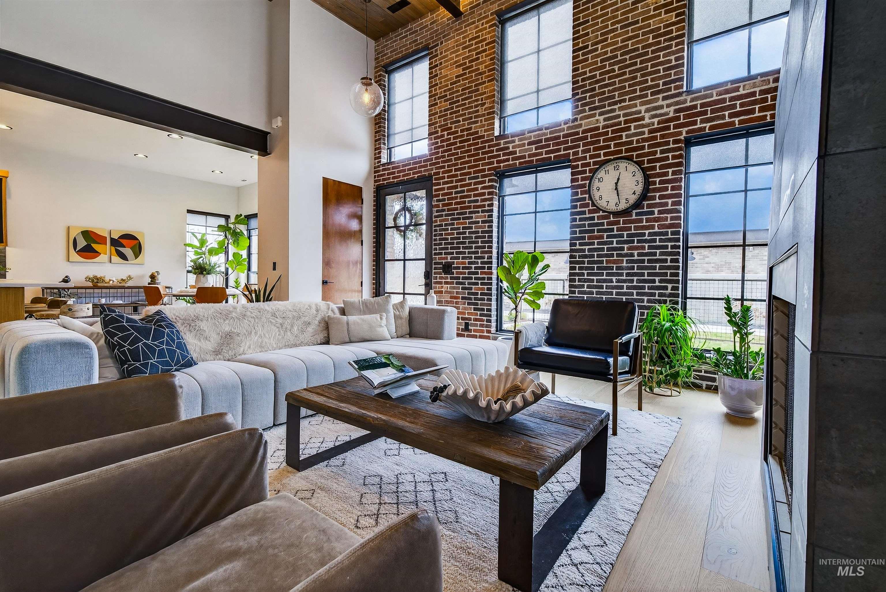 2526 West Rustic Forge Street Eagle, ID 83616 - Photo 19 of 50 Living room featuring brick wall, hardwood / wood-style flooring, a high ceiling, and a fireplace