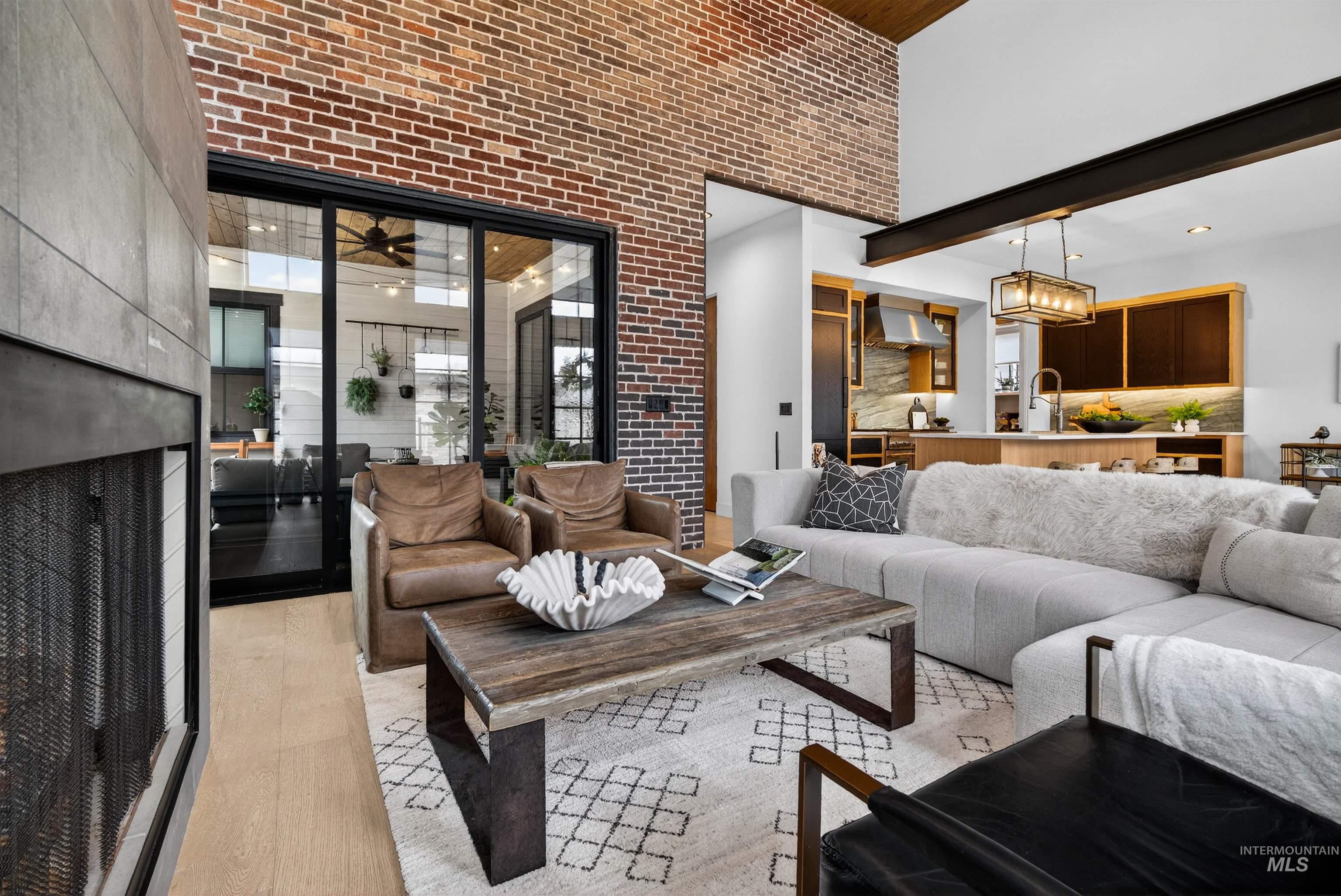 2526 West Rustic Forge Street Eagle, ID 83616 - Photo 20 of 50 Living area with a high ceiling, light wood-style flooring, brick wall, a fireplace, and recessed lighting