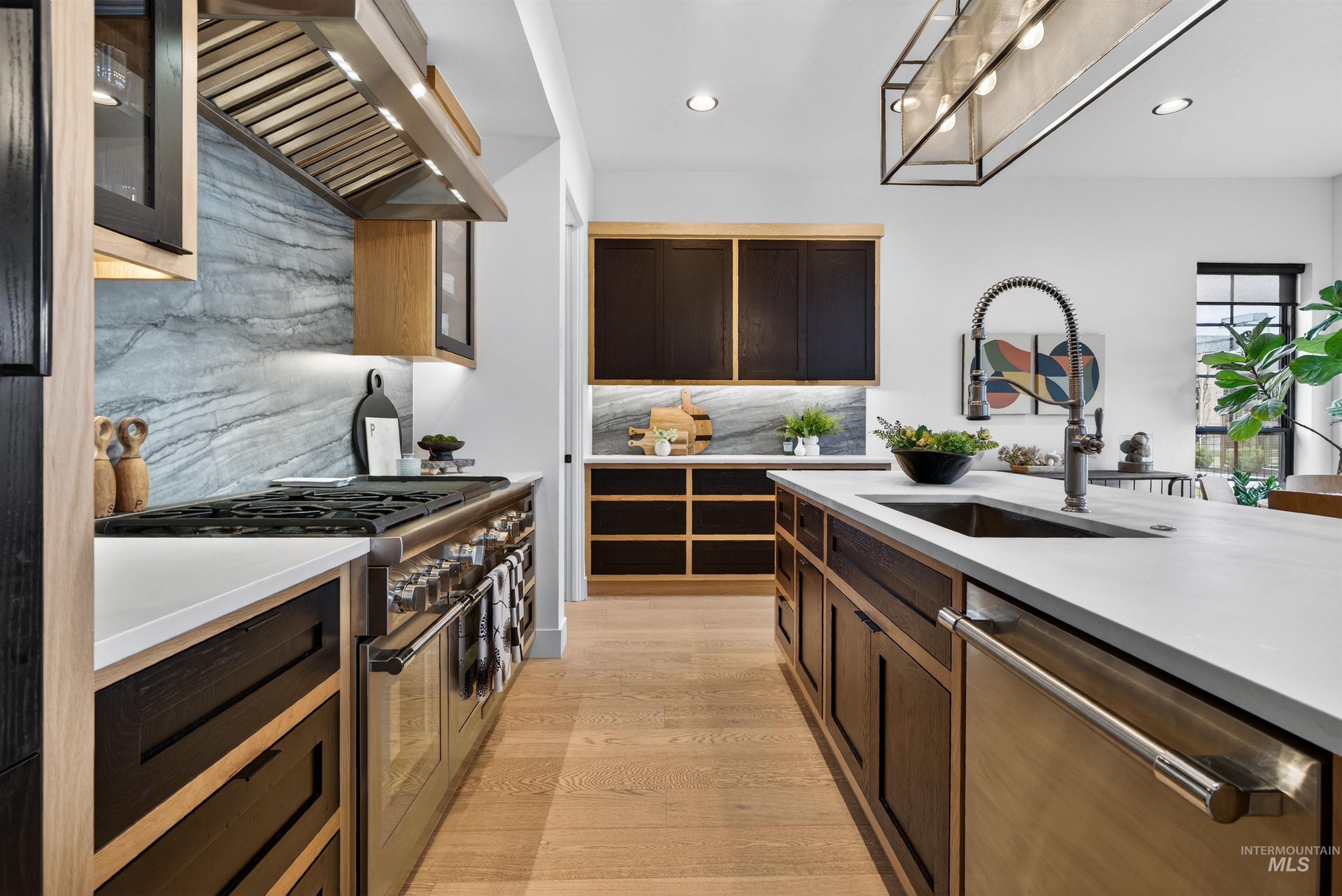 2526 West Rustic Forge Street Eagle, ID 83616 - Photo 27 of 50 Kitchen featuring backsplash, stainless steel appliances, light wood-style floors, glass fronted cabinets, and light stone counters