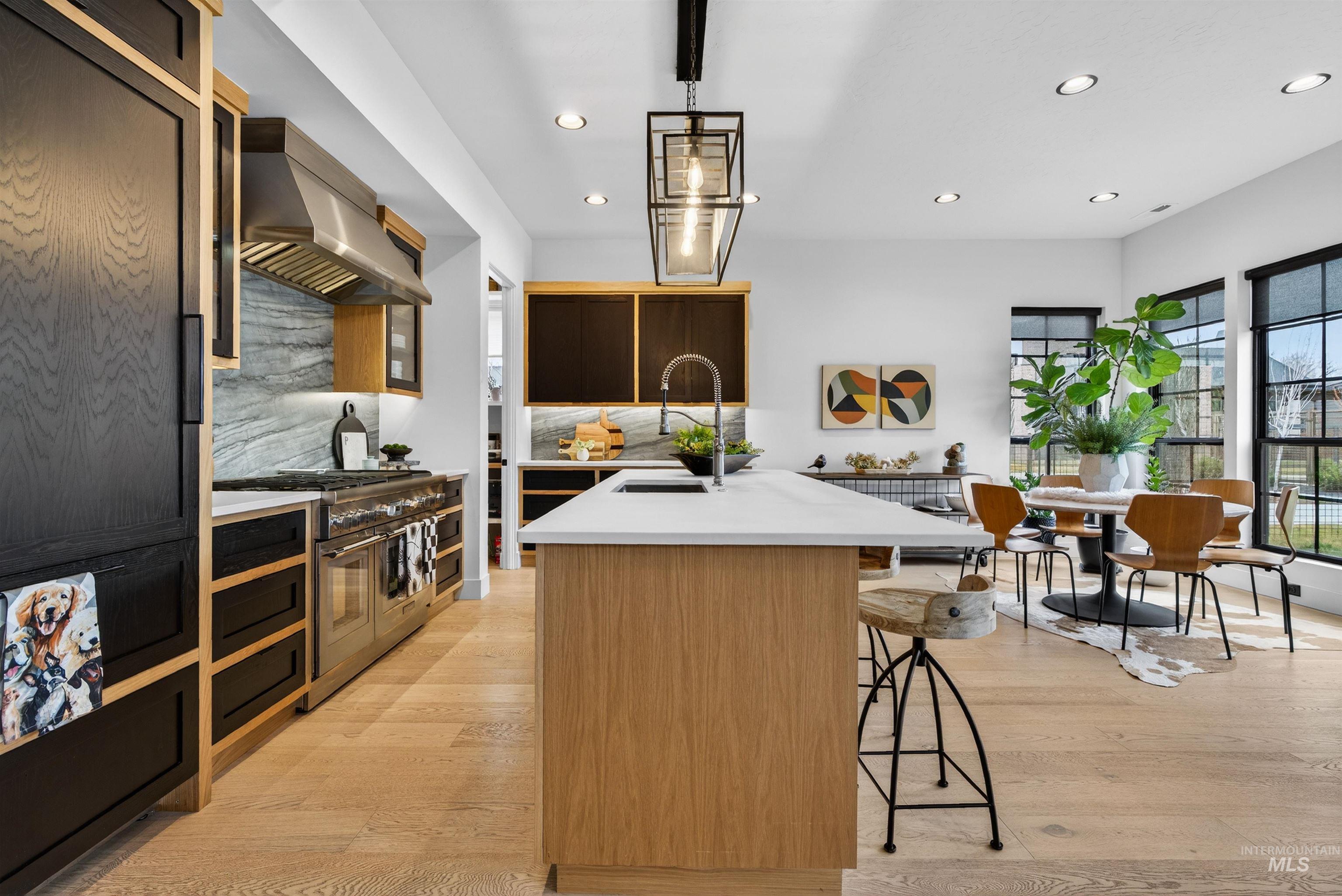 2526 West Rustic Forge Street Eagle, ID 83616 - Photo 28 of 50 Kitchen featuring a kitchen island with sink, a kitchen bar, pendant lighting, double oven range, and tasteful backsplash