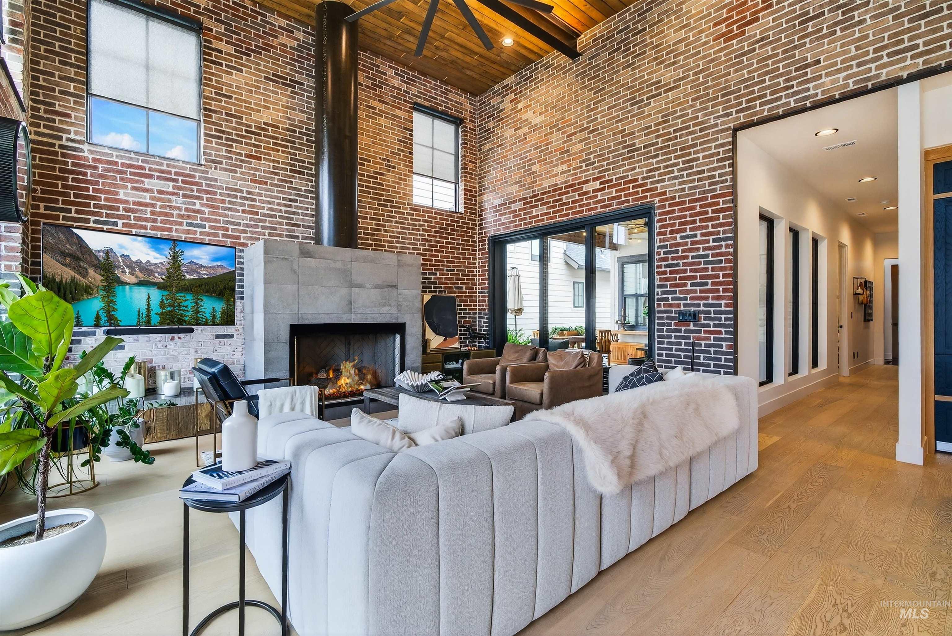 2526 West Rustic Forge Street Eagle, ID 83616 - Photo 30 of 50 Living room featuring wood finished floors, recessed lighting, brick wall, a tile fireplace, and a high wood ceiling