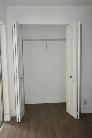 an empty room with wooden floor and entrance