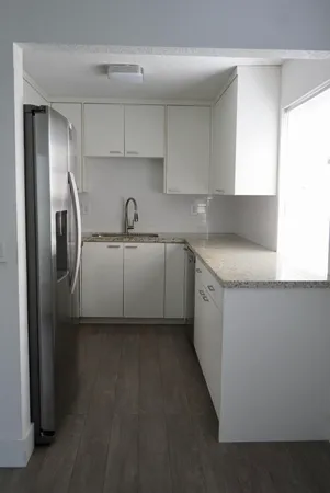 a kitchen with stainless steel appliances granite countertop a sink a stove and a refrigerator