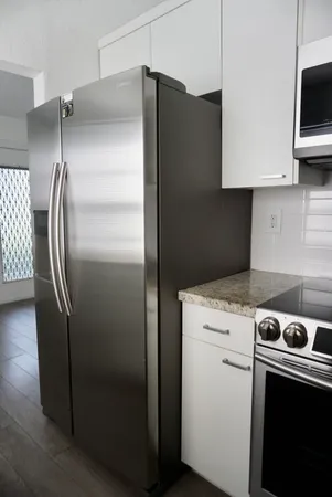 a kitchen with metallic refrigerator and a stove top oven