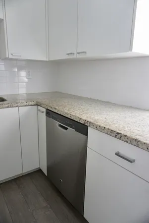 a kitchen with granite countertop white cabinets and white appliances